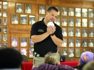 Fire Inspector Casey Pickel sounding smoke alarm