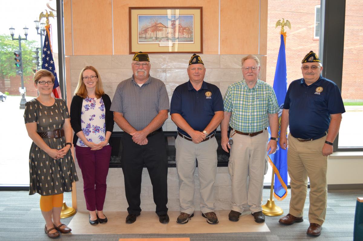 Photo of Library Director and Board President with members of VFW and American Legion and displayed flags